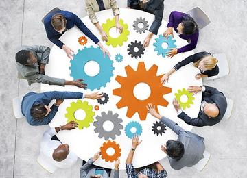 people sitting in circle with cogwheels